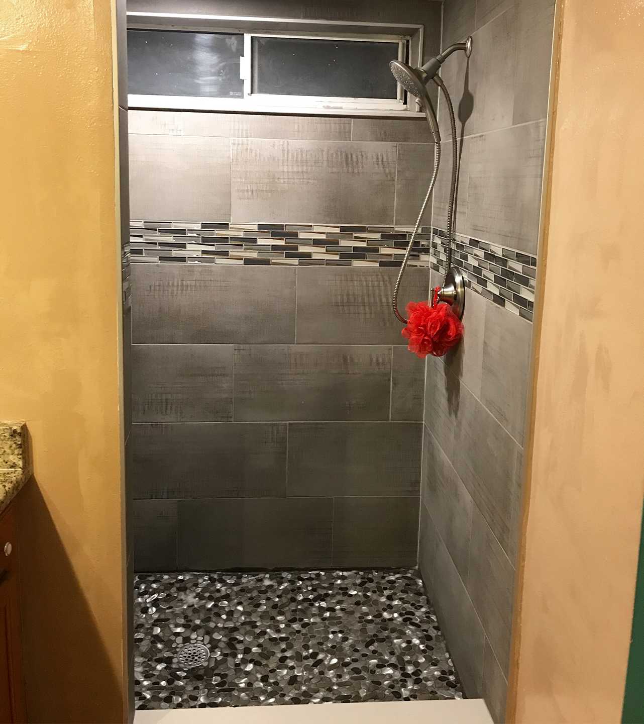Charcoal and gray slate tile make up a beautiful renovated shower