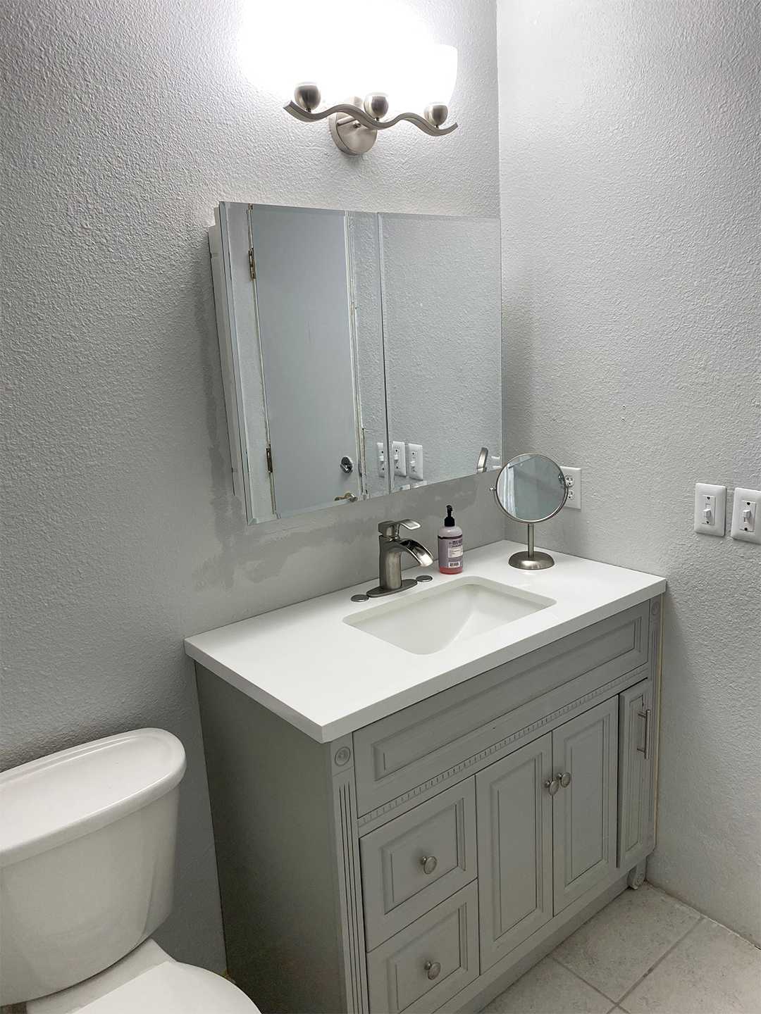 White bathroom with renovated shower and vanity