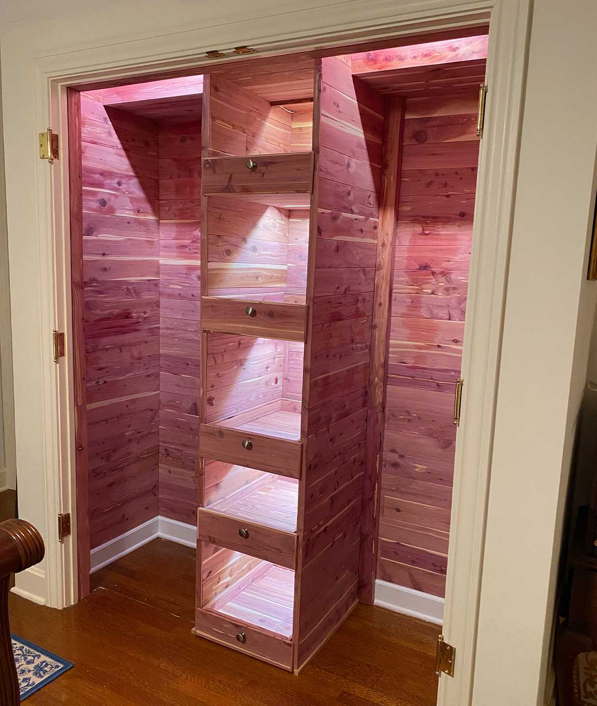New cedar closet with custom shelf lighting and drawers